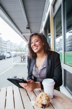Afro-Amerikalı iş kadını tabletini okuyor.