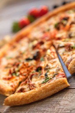 Tahta bir masada pizza.
