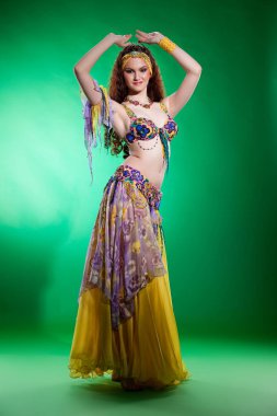 Geleneksel doğu dansı kıyafeti giymiş genç bir kadın.