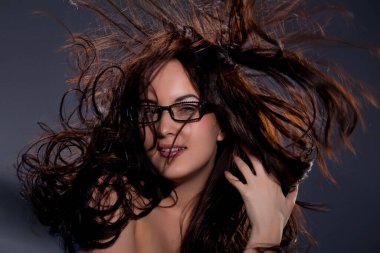 Siyah bir stüdyoda genç, üstsüz bir kadın.