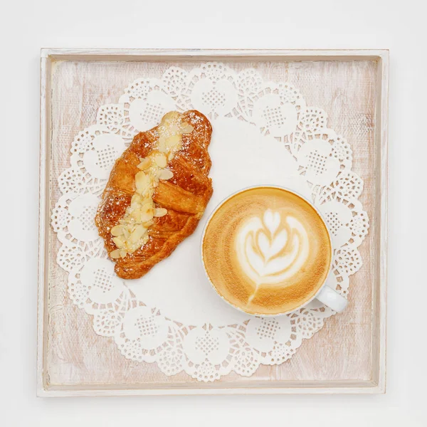 cappuccino and croissant on a tray