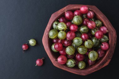 Siyah arka planda bir kasede taze bektaşi üzümü