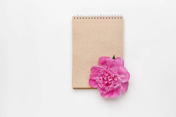 Mínimo estilo plano con peonía flor y cuaderno kraft Fotos De Stock