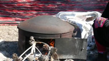 Portatif bir sobada, ağaç dalları ve çam kozalaklarından yakacak odunları olan Pita Arap yassı ekmeği pişirmek.