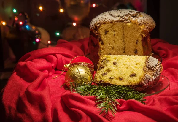 Kesin panettone, yeşil dal, baubles, bulanık ışıklar. Noel Tema.