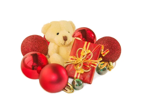 Teddybär mit Geschenk und Christbaumkugeln auf weiß. — Stockfoto