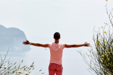 Adam bakıyor deniz ve kayalar