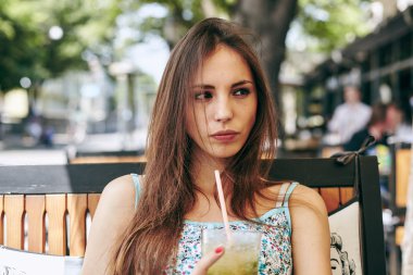 Kadın restoranda kokteyl içiyor. 