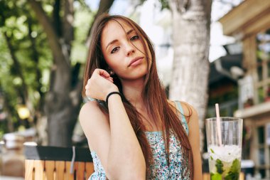 Kadın restoranda kokteyl içiyor. 