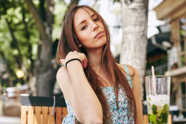 Kadın restoranda kokteyl içiyor. 