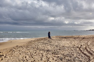 Deniz kenarında yürüyen kadın