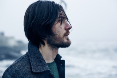 Denize yakın yürüyüş gri paltolu adam