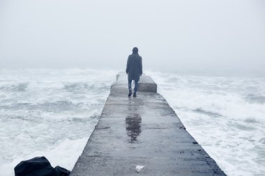 Denize yakın yürüyüş gri paltolu adam