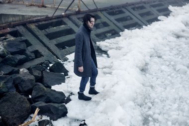 Denize yakın yürüyüş gri paltolu adam