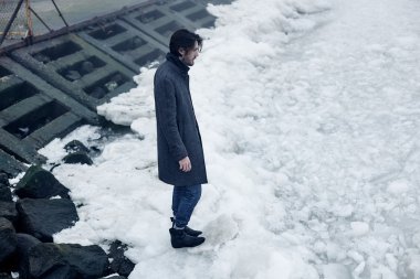 Denize yakın yürüyüş gri paltolu adam