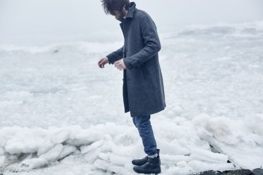 Denize yakın yürüyüş gri paltolu adam