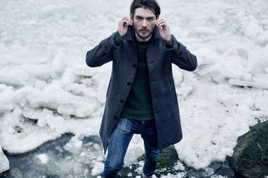 Denize yakın yürüyüş gri paltolu adam