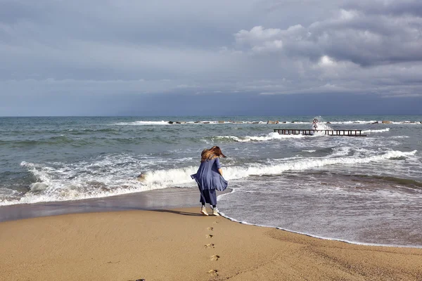 Kvinnan promenader vid havet — Stockfoto