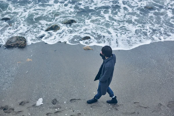 Denize yakın yürüyüş gri paltolu adam — Stok fotoğraf