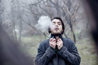 Denize yakın yürüyüş gri paltolu adam