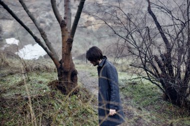 Denize yakın yürüyüş gri paltolu adam