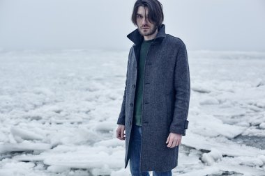 Denize yakın yürüyüş gri paltolu adam