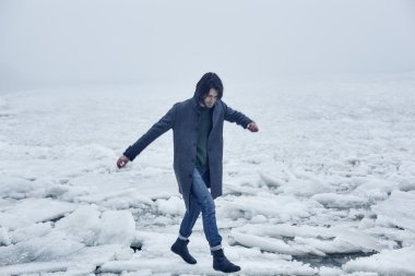 Denize yakın yürüyüş gri paltolu adam