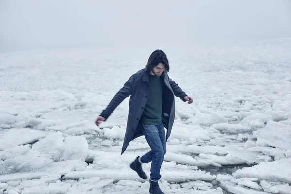 Mann im grauen Mantel geht am Meer spazieren — Stockfoto