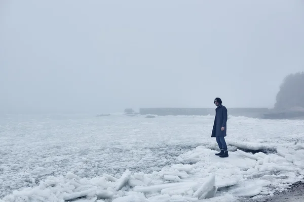 Man i grå jacka gå nära havet — Stockfoto