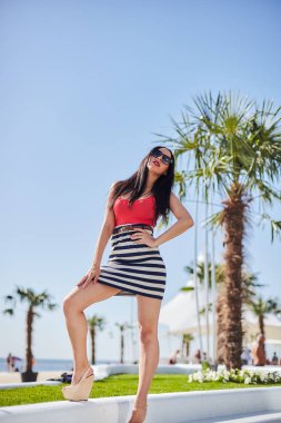 dar elbiseli seksi esmer güzel sahil güneşli bir günde yürür.