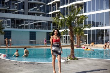 dar elbiseli seksi esmer güzel sahil güneşli bir günde yürür.