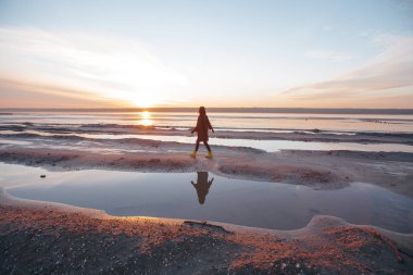 Kız bir ceket göl üzerinde yürüyor