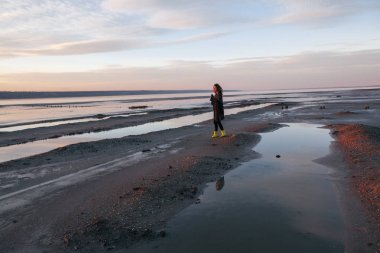 Kız bir ceket göl üzerinde yürüyor