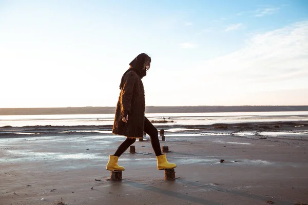 Fille dans un manteau marche sur le lac — Photo