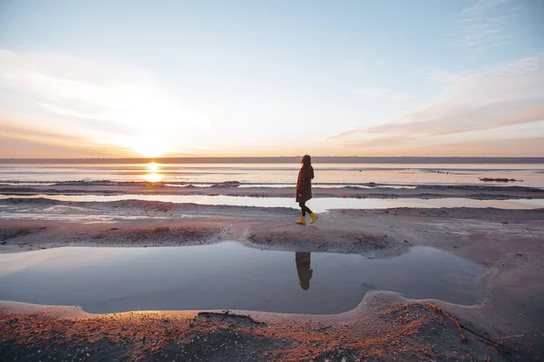 Fille dans un manteau marche sur le lac — Photo