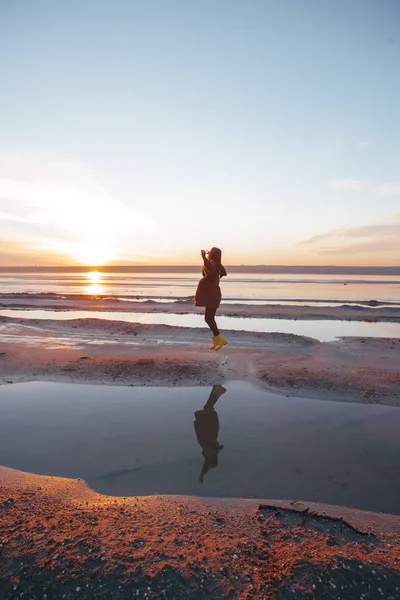 Fille dans un manteau marche sur le lac — Photo