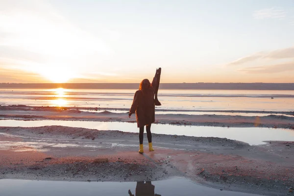 Chica en un abrigo camina por el lago — Foto de Stock