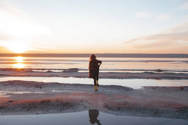 Fille dans un manteau marche sur le lac — Photo