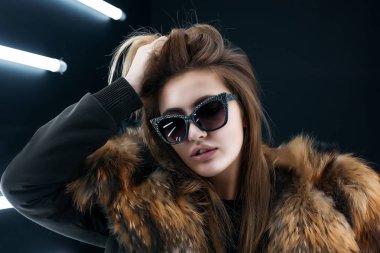 Hipster genç kız duvardan poz güneş gözlüğü