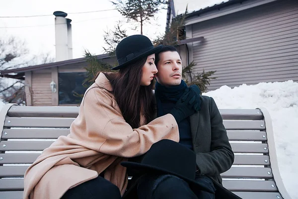 Girl embracing man sitting on bench — Stock Photo, Image