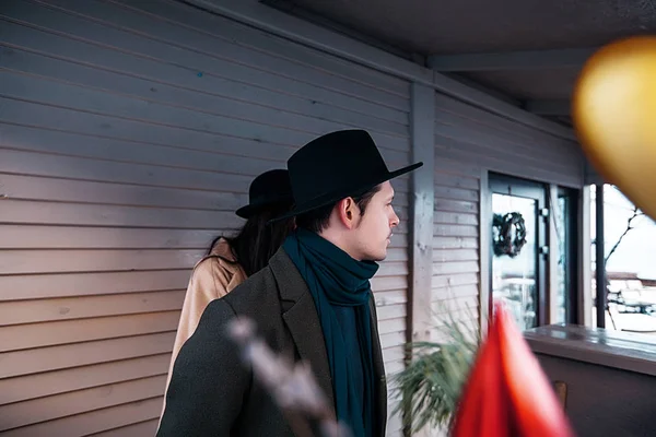 Romance couple in coats standing on terrace — Stock Photo, Image