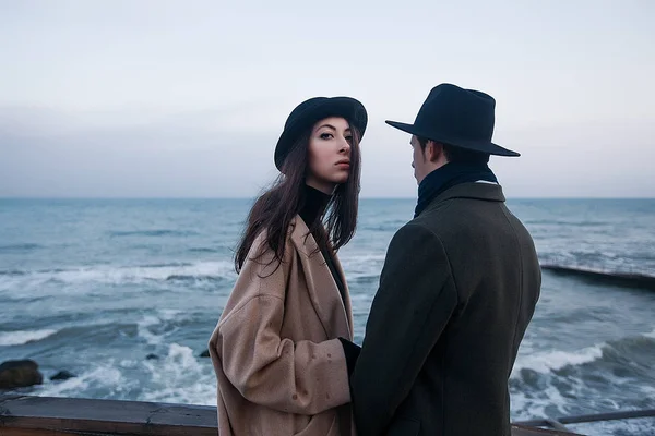 Couple in coats and hats standing on terrace — Stock Photo, Image