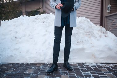 house yakınındaki elinde şapka ile paltolu adam