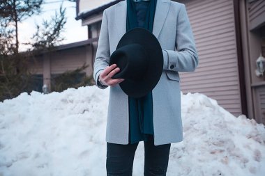 house yakınındaki elinde şapka ile paltolu adam