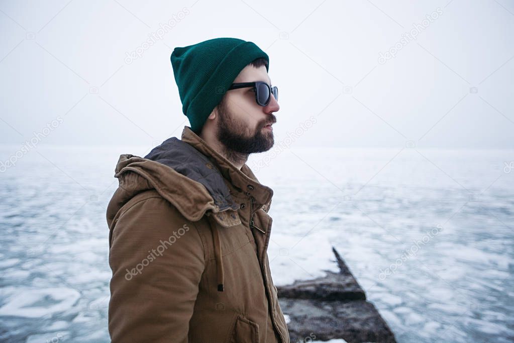 young hipster standing on pier in winter