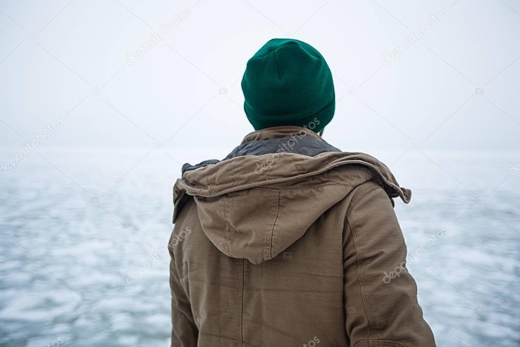 young hipster standing on pier in winter
