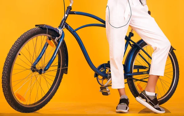 Jovem com bicicleta retro em pé na frente de fundo amarelo, dias de ajuste esportivo, roupas casuais, andar de bicicleta vintage, estilo de moda de rua, descobrir, emoções — Fotografia de Stock