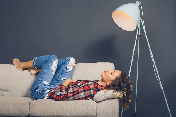 Young woman lying on couch — Stock Photo, Image