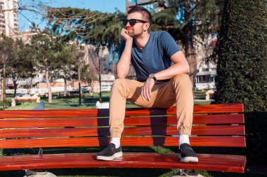 adam bankta oturan güneş gözlüğü