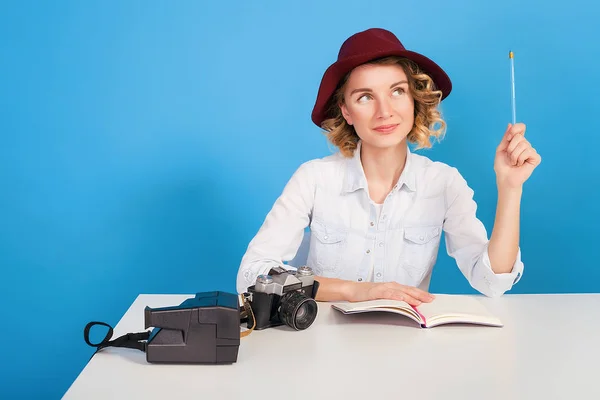 Beautiful woman in hat sitting at table — Stock Photo, Image